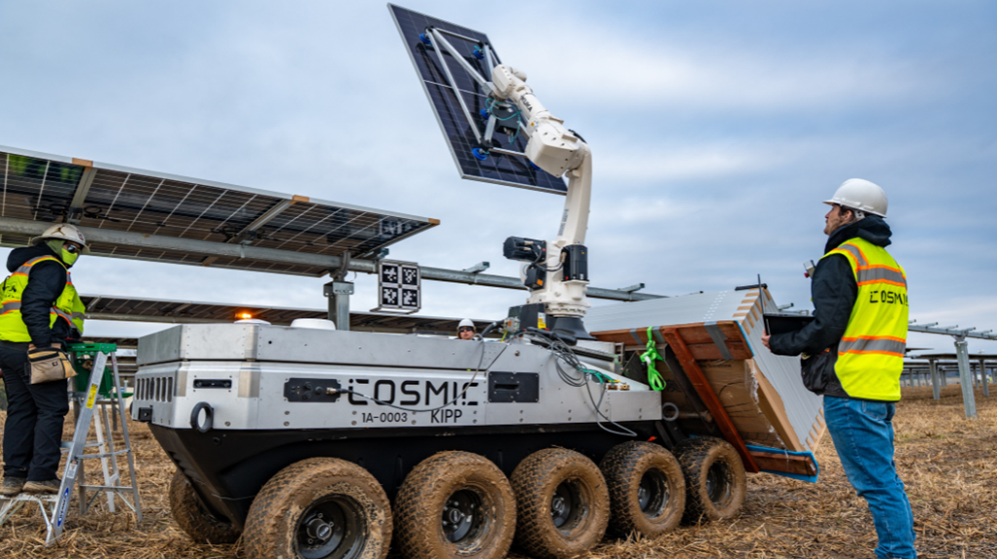 Workers collaborate with a robotic system to install solar modules in a large-scale renewable energy project.