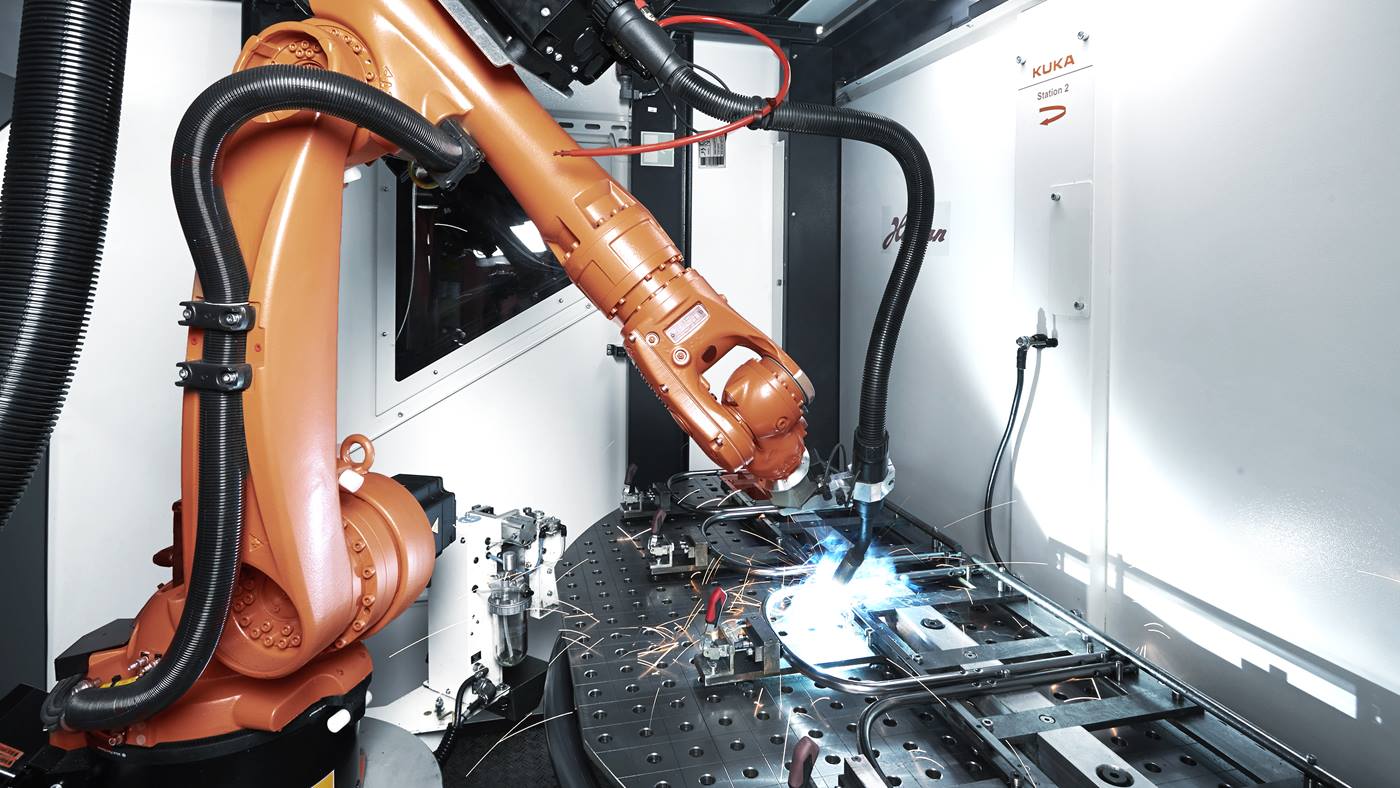 Roboter im KUKA flexibleCUBE beim Schweißen