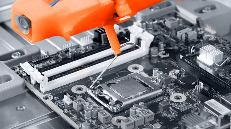 Using sensitive force motion, the robot mounts a CPU and RAM module on the motherboard of a PC.