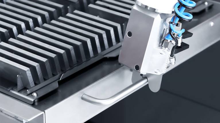 装料机器人拉开抽屉,从中取出待加工的工件。